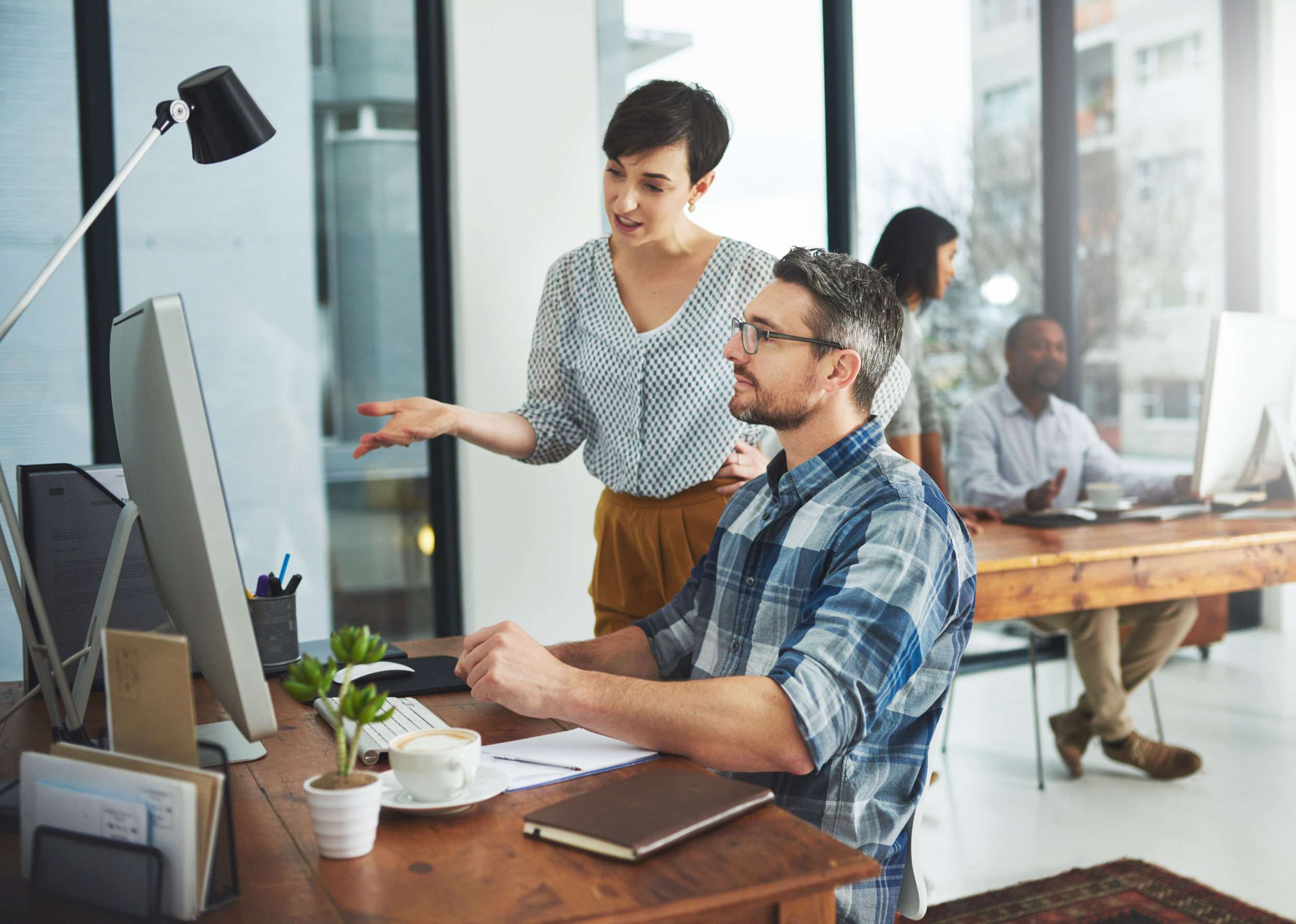 photo of two colleagues working on to implement different types of SEO for their business.