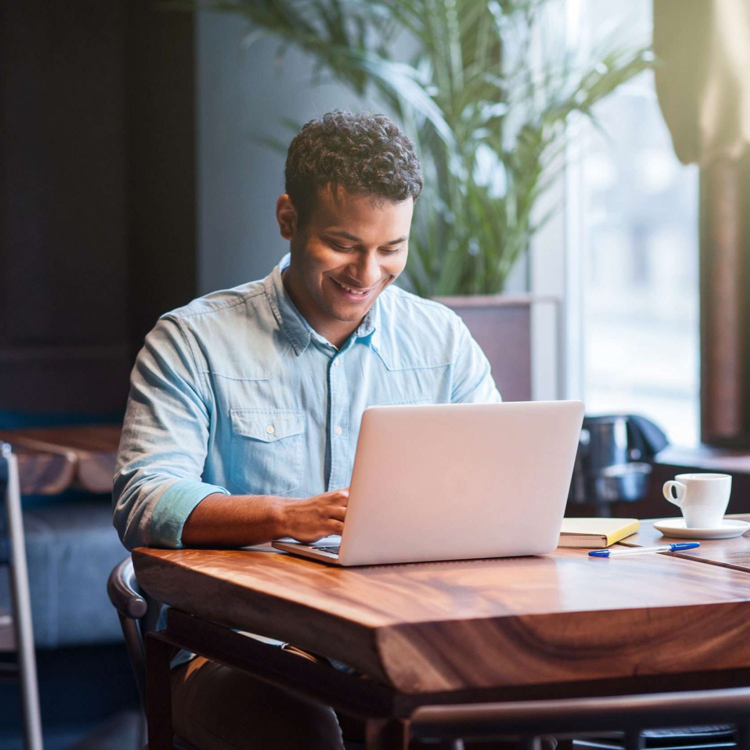Small business owner smiling while working on a laptop, representing ADA web accessibility compliance for local businesses